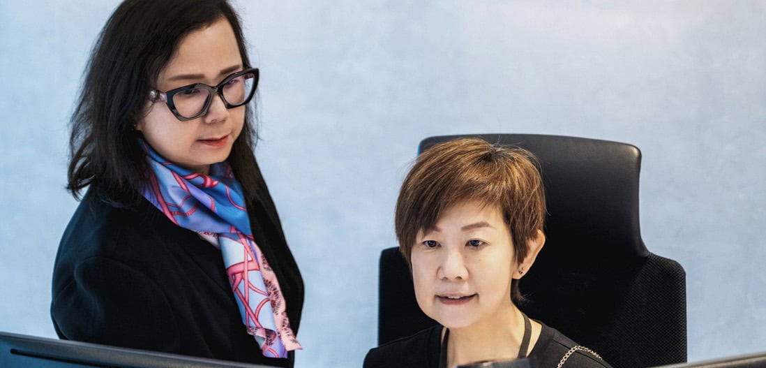 To ansatte jobber foran PC-en på Singapore-kontoret til Norges Bank Investment Management.