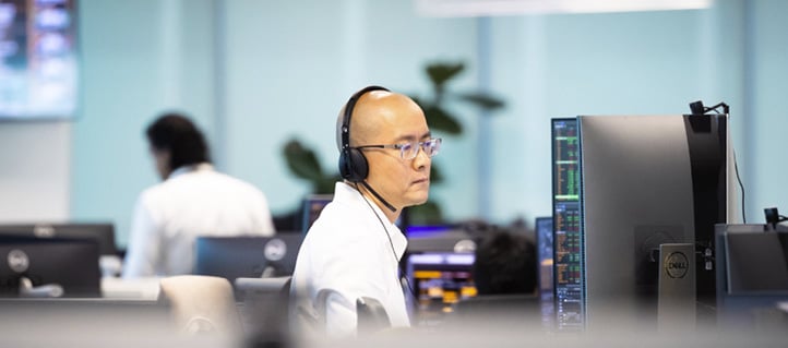 Employee working at a desk with headset in the Singapore office.