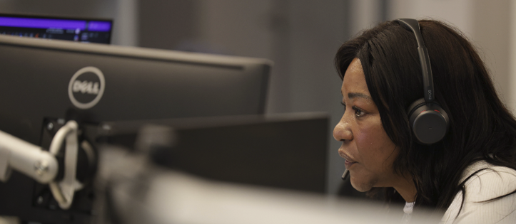 Employee working at a computer with a headset at the New York office.