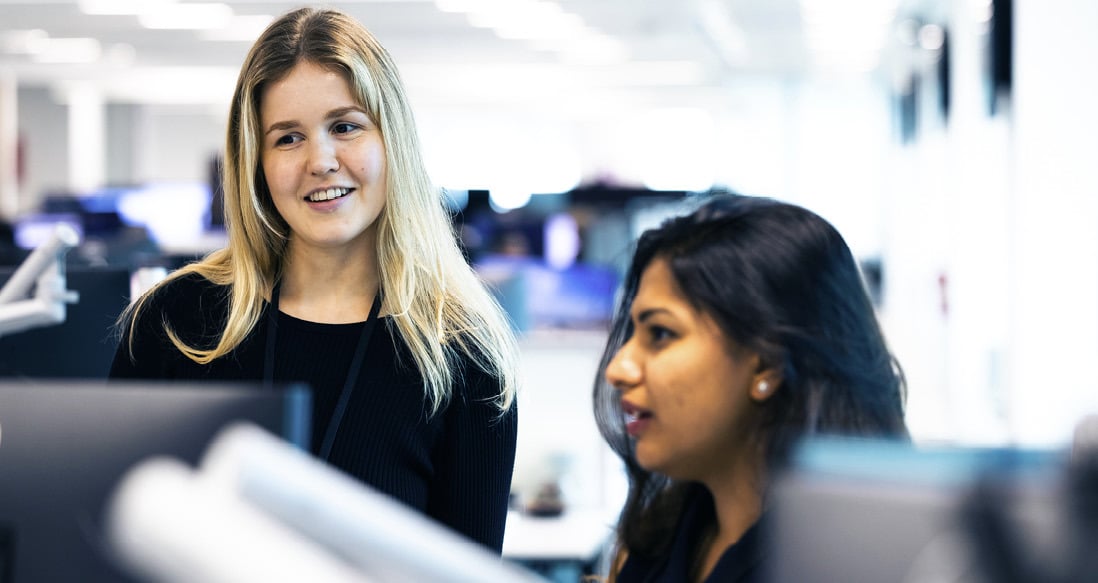 To ansatte i samtale ved Singapore-kontoret.