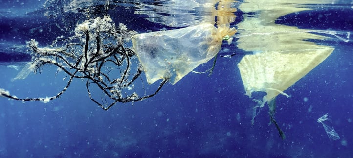 Plastic waste floating in the ocean just below the water surface.