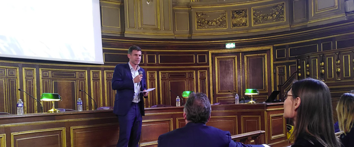 Mann som holder innlegg under FIR&ndash;PR Awards-seremonien ved Sorbonne-universitetet i Paris, med publikum i en historisk sal.