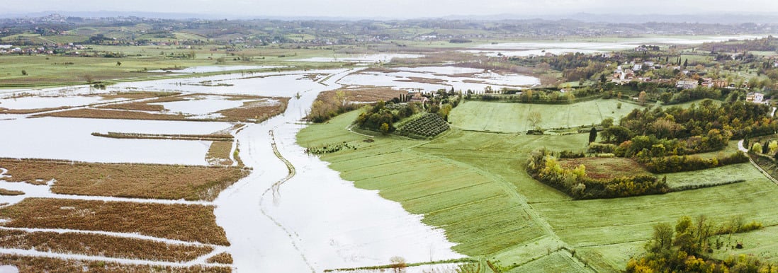 Luftfoto av oversv&oslash;mte jordbruksomr&aring;der og omkringliggende landskap.