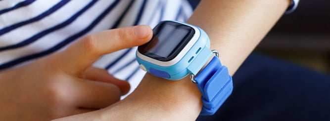 Barn med smartklokke som ber&oslash;rer skjermen.